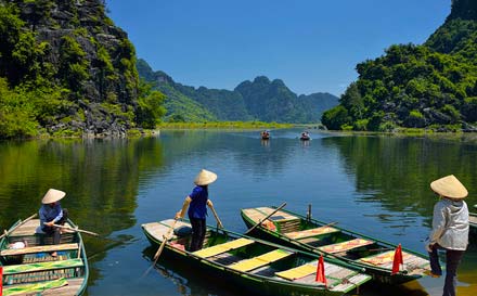 Photographie d'une riviére avec des navigateur sur des barques au vietnam