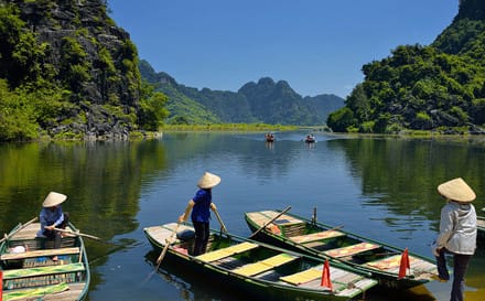 Photographie d'une riviére avec des navigateur sur des barques au vietnam